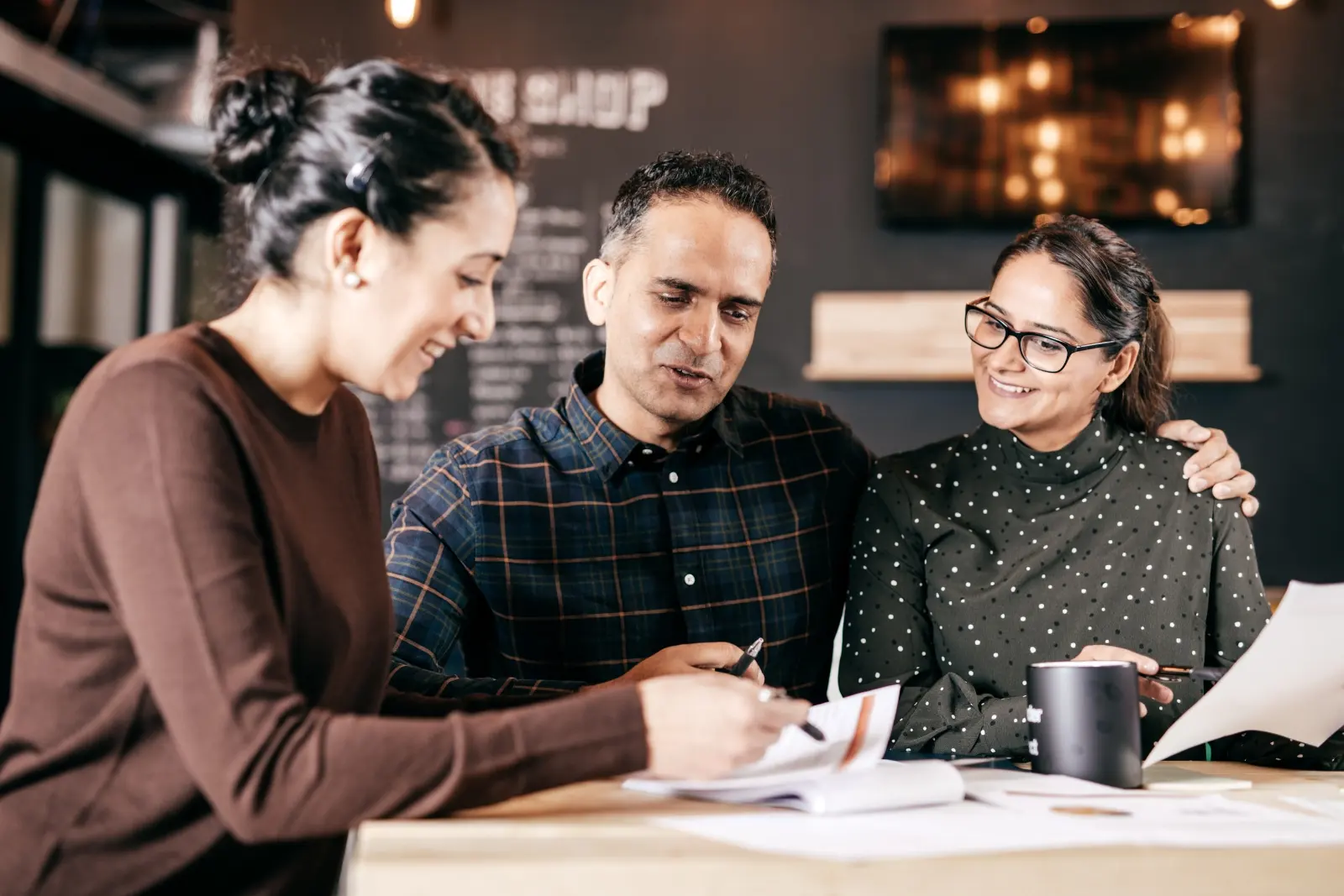 Equipo revisando documentación junto a una agente en una mesa de trabajo