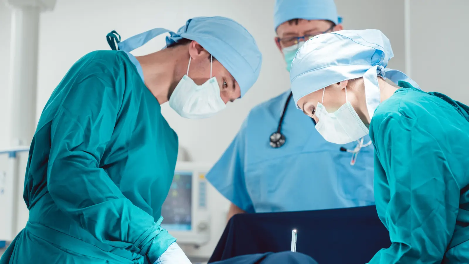 Equipo quirúrgico con gorro y cubrebocas operando en un quirófano